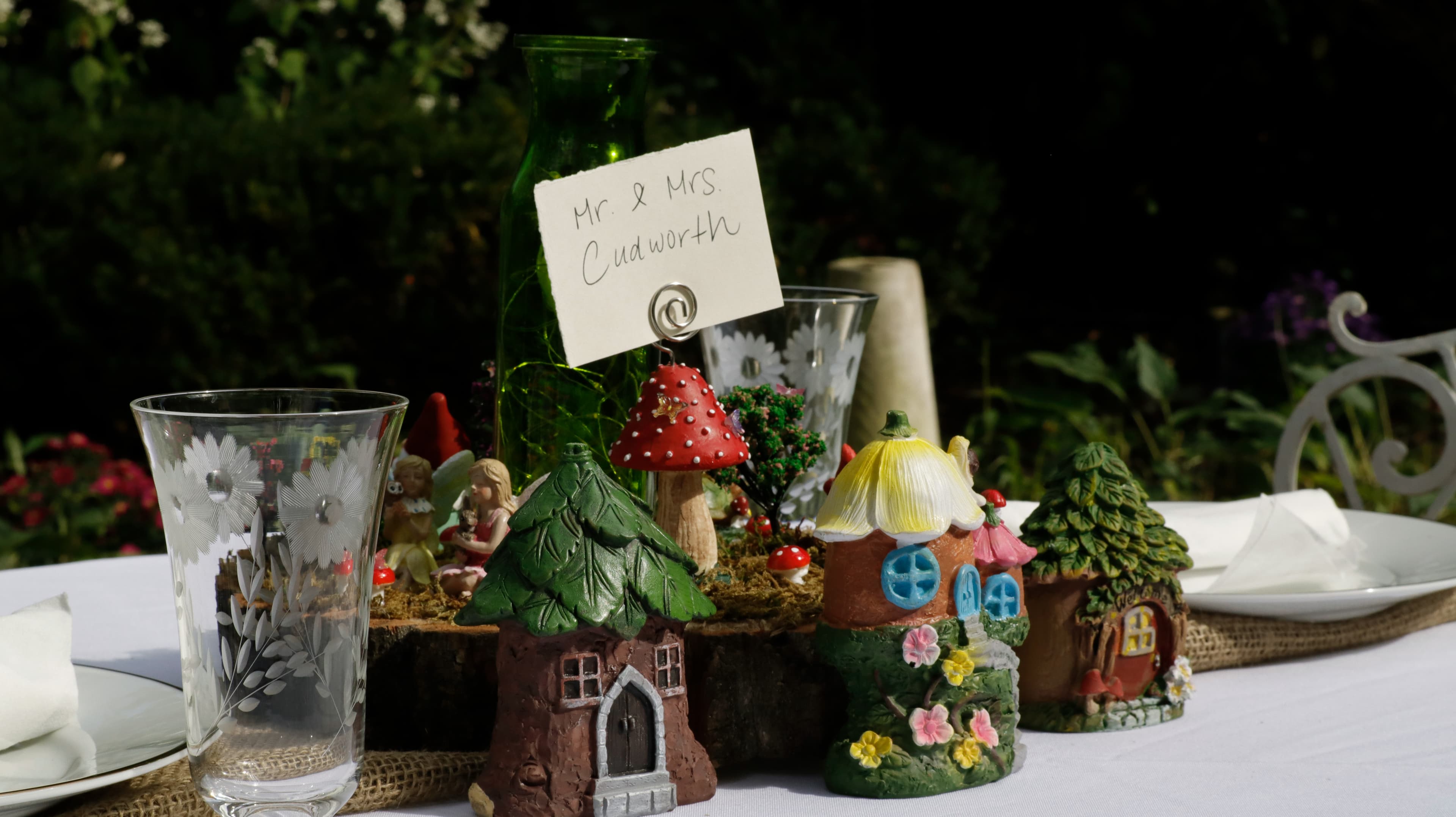 A beautifully set table featuring whimsical fairy-themed decorations and a name card for Mr. and Mrs. Cudworth.