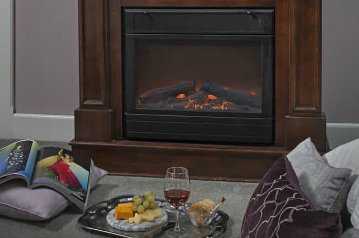 fireplace, glass of red wine and fruit/cheese plate