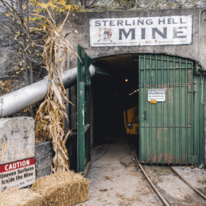 Entrance to Sterling Hill Mine in Ogdensburg NJ, featuring historic mine adit with green metal gate and warning signs